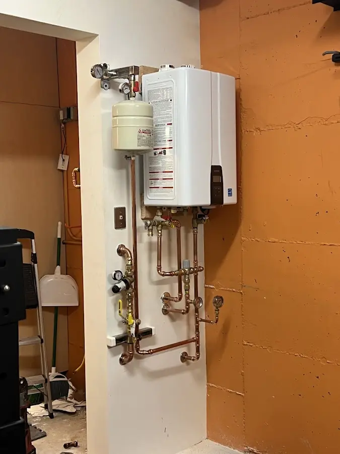 Plumbing technician inspecting water heater connections in Flossmoor